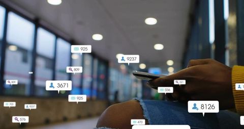 Traveler checking smartphone with social notification bubbles in modern station concourse