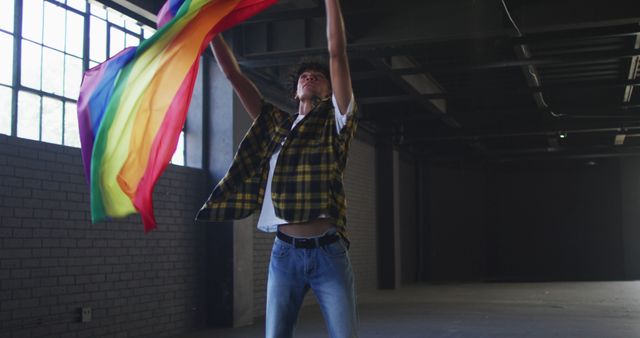 Young Person Waving Rainbow Flag in Industrial Building - Download Free Stock Images Pikwizard.com