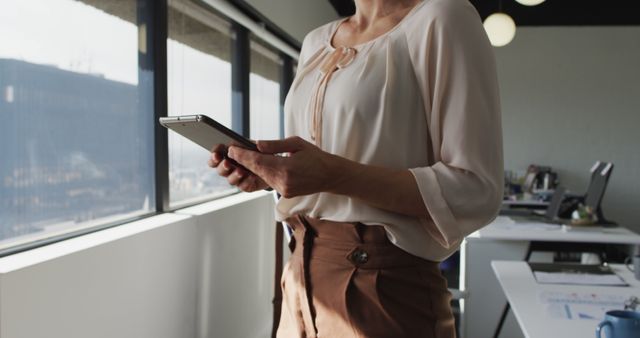 Businesswoman Holding Tablet Near Office Windows - Download Free Stock Images Pikwizard.com