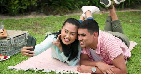 Smiling Couple Taking Selfie During Picnic in Park