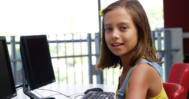 Young girl is learning at a computer in a classroom setting, showcasing modern educational technology. Perfect for educational content, technology ads, or school brochures promoting digital literacy.