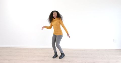 Woman Dancing Energetically in Bright Minimalist Room
