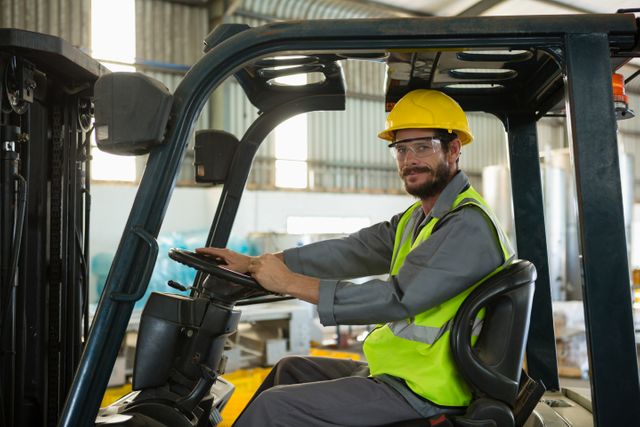 Portrait of smiling worker driving a forklift car in factory