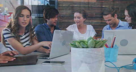 Diverse Team Analyzing Financial Data on Laptops in Office