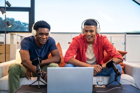 Diverse male friends podcasting together in modern living room