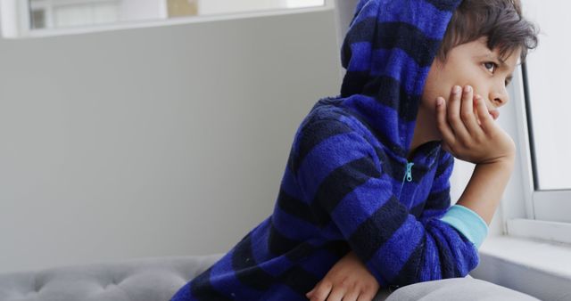 Thoughtful Young Boy Daydreaming by Window in Striped Hoodie - Download Free Stock Images Pikwizard.com