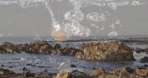 Tranquil coastal scene with bubbles and jagged rocks