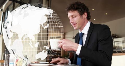 Businessman Amidst Futuristic Global Interface with Smartphone