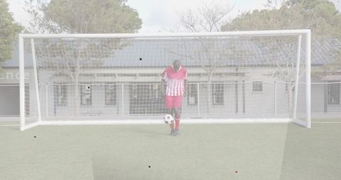 Balancing soccer player controlling ball inside goal on synthetic turf, training promotion