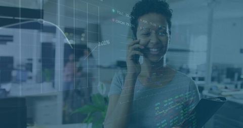 Smiling professional using phone and clipboard with financial data overlays in office