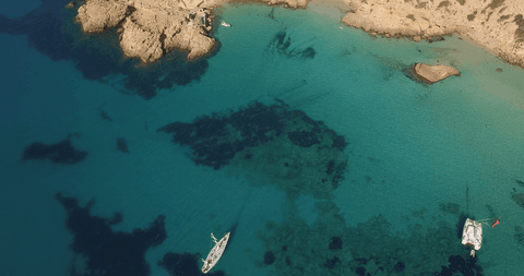 idyllic aerial coastal view with boats in transparent blue waters - Download Free Stock Videos Pikwizard.com
