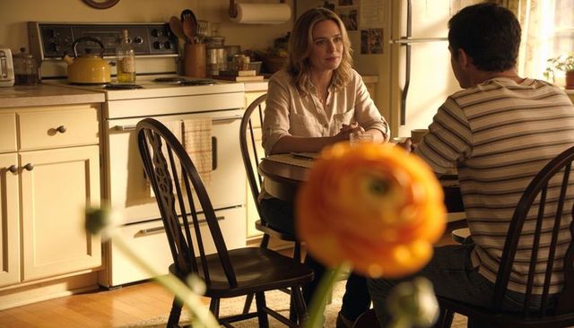 Couple sharing quiet morning conversation at sunlit cozy kitchen table