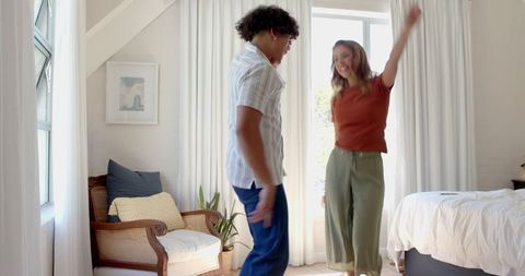 Joyful Couple Dancing Together in Bright Bedroom
