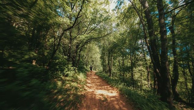 Man Running Through Forest Trail with Hydration Pack