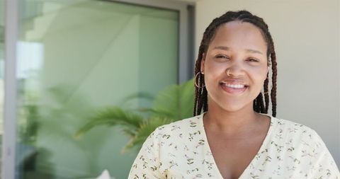 Smiling Young Biracial Woman with Plants in Tranquil Home