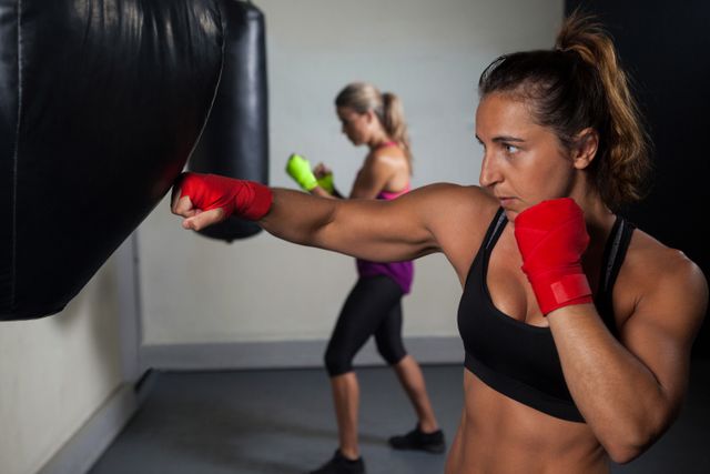 Determined women practicing boxing in fitness studio