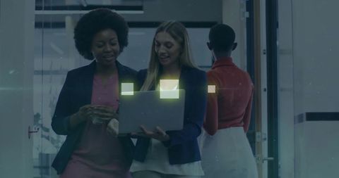 Professional Women Collaborating in Office Hallway Together