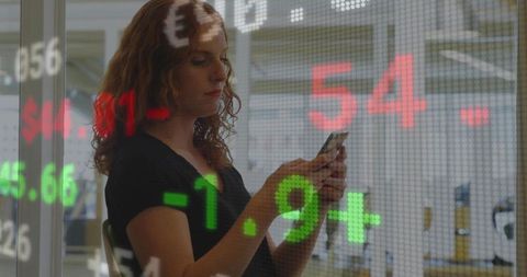 Red-haired Professional Using Smartphone with Stock Ticker Data