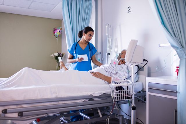 Female doctor consoling senior patient in hospital ward. Ideal for use in healthcare, medical care, patient support, and hospital-related content. Can be used in articles, brochures, and websites focusing on elderly care, medical treatment, and healthcare services.
