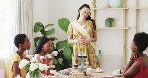 Joyful women's gathering with cupcakes and tea at home celebration