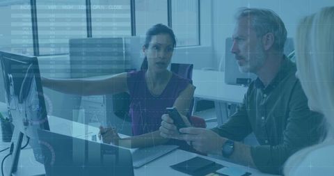 Female Tech Lead Pointing at Monitor Leading Data-Driven Team Meeting with HUD Overlay