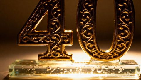 Ornate gold number 40 on glass base with warm backlight and bubble details for anniversary