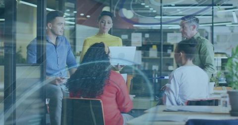 Woman Presenting in Glass-Walled Office Leading Collaborative Team Meeting