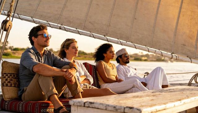 Sunset felucca cruise with diverse passengers relaxing on deck during golden hour