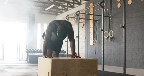 Man Resting After Intense Exercise at Industrial Gym with CrossFit Equipment