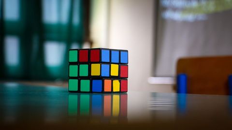 Rubik's cube on table in dimly lit room