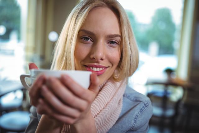 Beautiful woman having a cup of coffee in cafÃ© - Download Free Stock Photos Pikwizard.com