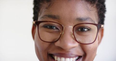 Close-up african woman smiling wearing brown eyeglasses warm friendly bright headshot
