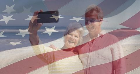 Happy Senior Couple Taking Selfie on Beach with American Flag Overlay