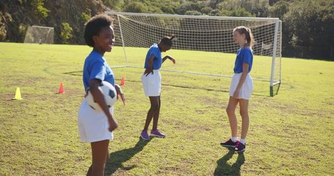Youthful Energy: Three Girls Enjoying Soccer on a School Field