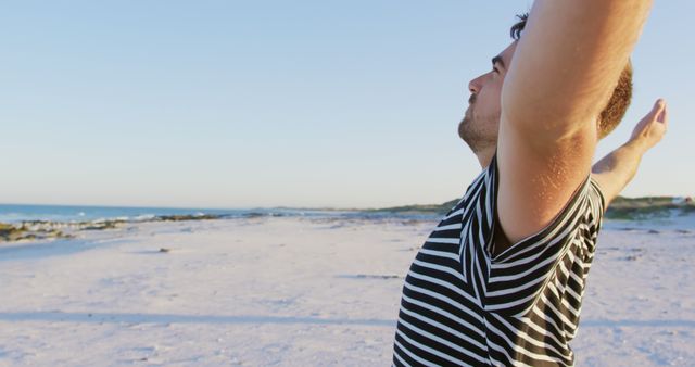 Happy caucasian man wearing striped tshirt with arms wide at beach - Download Free Stock Photos Pikwizard.com