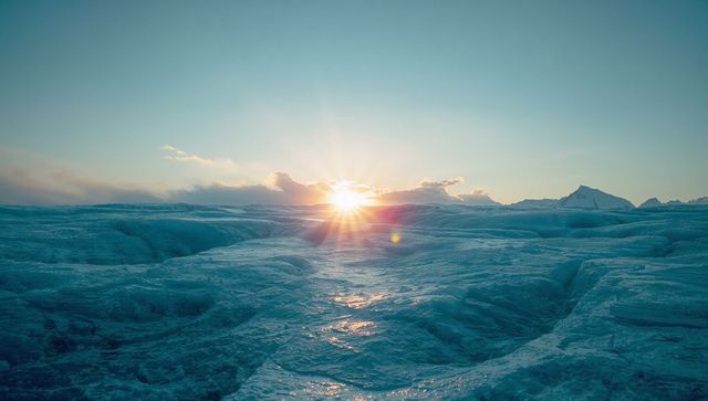 Sunrise Over Arctic Glacier with Cracks and Peaks