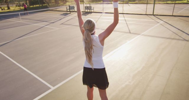Image of back of caucasian female tennis player holding racket and hitting ball. professional tennis training, sport and competition concept.