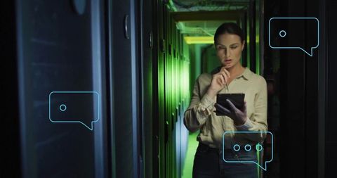 Female IT Technician Monitoring Server Racks with Tablet in Green-Lit Data Center Corridor