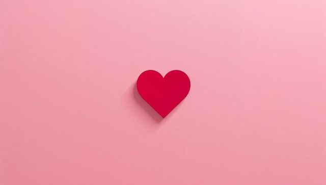 Floating crimson heart casting soft drop shadow on pastel pink background for Valentine design