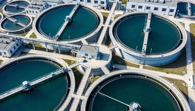 Aerial water treatment plant featuring circular clarifiers, rotating scraper arms, walkways