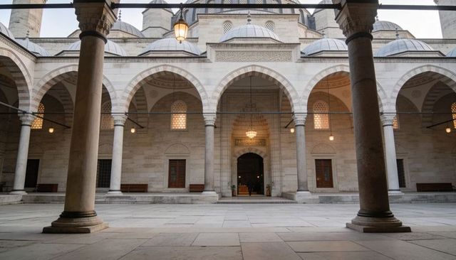 Historic ottoman courtyard showcasing arched colonnade, central dome and stone pillars