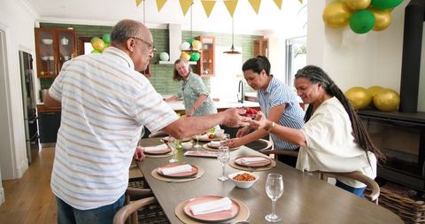 Seniors setting dining table for joyful dinner gathering