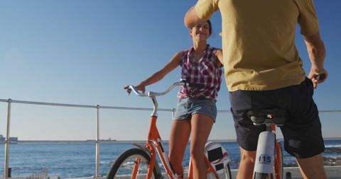 Happy Couple Riding Bicycles Along Seaside Promenade