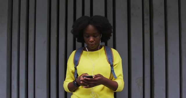 Young Woman Standing against Urban Wall, Looking at Smartphone - Download Free Stock Images Pikwizard.com