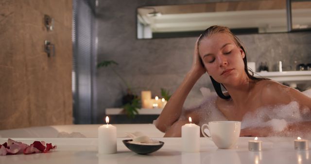 Woman enjoying relaxing bubble bath with candles and cup of tea - Download Free Stock Images Pikwizard.com