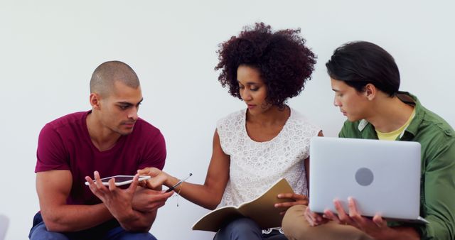 Diverse group discussing project using digital devices and documents - Download Free Stock Images Pikwizard.com