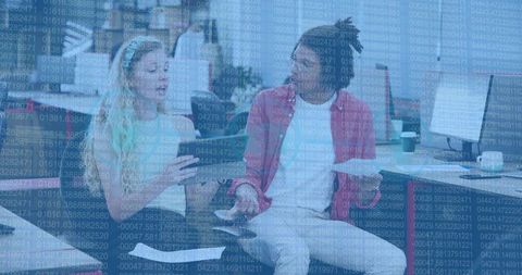 Collaborating over data-driven project in open office lounge with digital code overlay