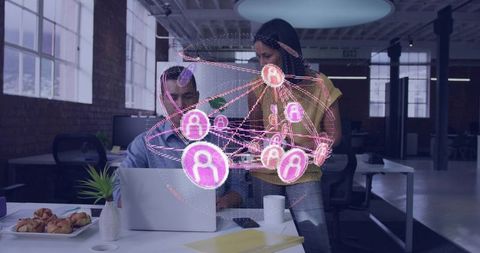 Team collaborating with holographic network over laptop in modern loft workspace