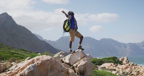 Triumphant Hiker Embracing Nature on Mountain Rock