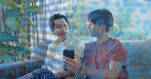 Parent and Teen Sharing Smartphone While Discussing Digital Privacy in Living Room